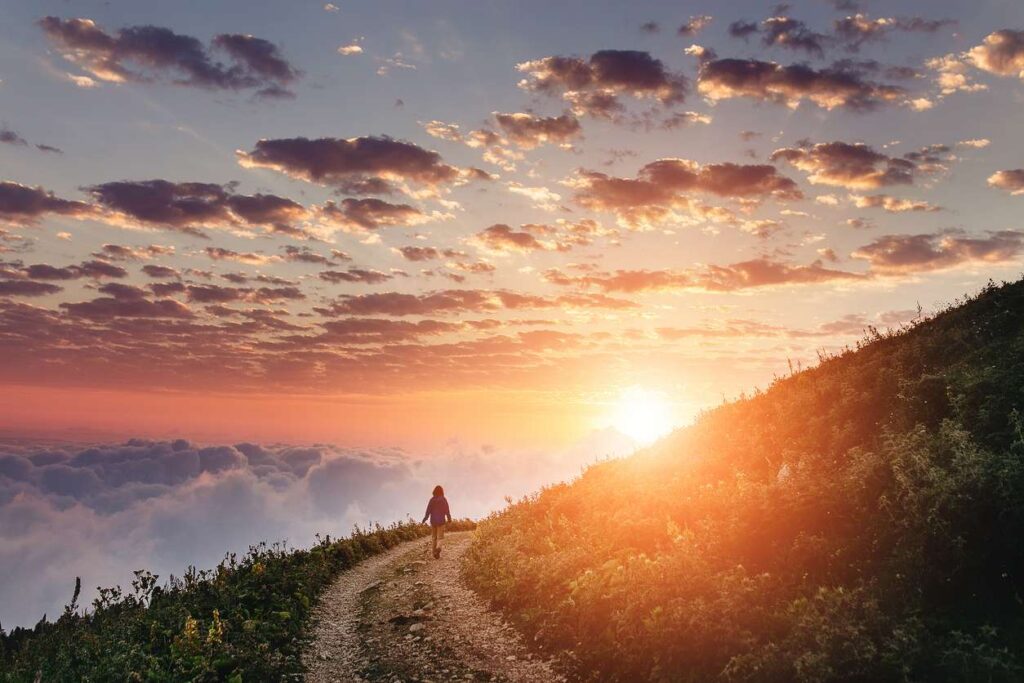 A vast image of the sun setting over a mountain