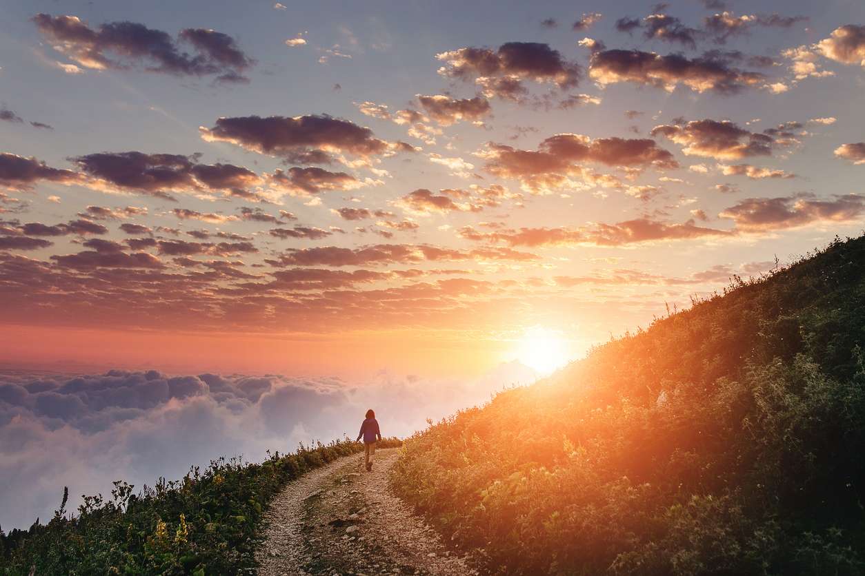A vast image of the sun setting over a mountain